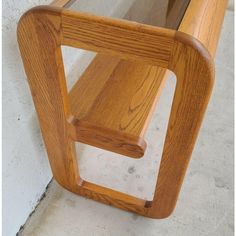 a wooden bench sitting next to a white wall