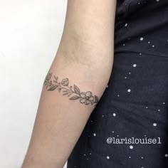 a woman's arm with a flower tattoo on the left side of her arm