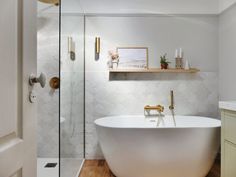 a white bath tub sitting next to a walk in shower