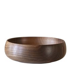 a wooden bowl sitting on top of a white wall