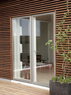 an outdoor patio with wooden slatted walls and sliding glass doors