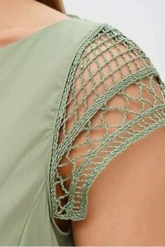 the back of a woman's green top with crochet on it