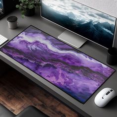 a computer desk with a purple and black marble mouse pad on it next to a keyboard