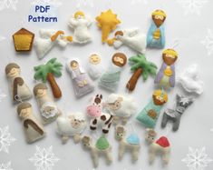 a collection of felt nativity ornaments on a white surface with snowflakes in the background