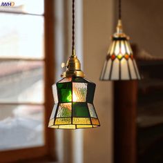 two stained glass lamps hanging from a ceiling