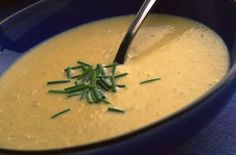 a blue bowl filled with soup on top of a table