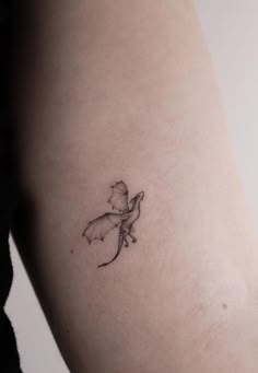 a small tattoo on the arm of a woman's left arm, with a little fairy