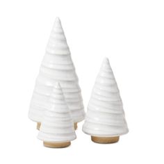 two white ceramic christmas trees sitting next to each other