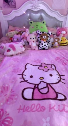 a hello kitty bed spread with stuffed animals on it