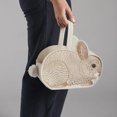 a person is holding a bag with a rabbit on it