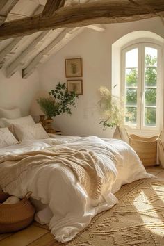 a bed sitting under a window in a bedroom next to a basket filled with flowers