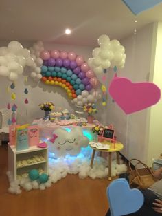 a room filled with lots of balloons and decorations on the walls, including a rainbow arch