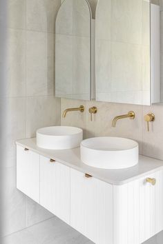 two white sinks sitting next to each other in a bathroom