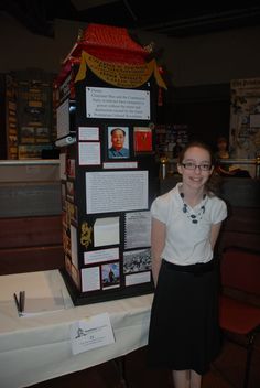 a woman standing in front of a tall tower with pictures on it's sides