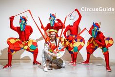 a group of people that are standing in the middle of a room with red and yellow costumes