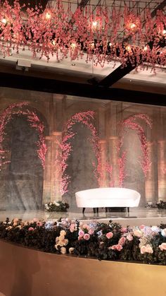 a room filled with lots of flowers and chandelier hanging from it's ceiling