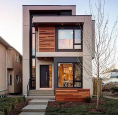 a two story house with wood and glass on the front