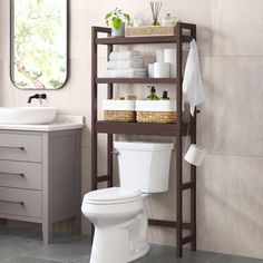 a bathroom with a toilet, sink and shelving unit