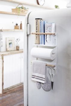 a kitchen with a refrigerator and some books on the shelf