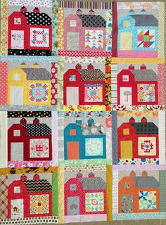 a quilted wall hanging with houses on it