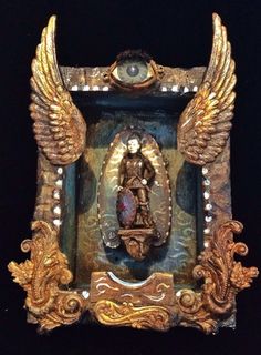 an ornate gold and blue frame with angel wings on it's sides, in the shape of a virgin mary