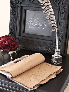 an old fashioned photo frame with a feather on it and some papers next to it