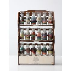 an old wooden spice rack with many jars on it