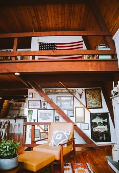 a living room filled with furniture and pictures on the wall next to a stair case