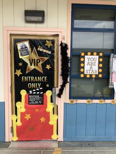 an entrance to a movie theater with a red carpet and yellow stars on the door