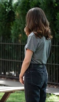 a woman standing in front of a picnic table with her back turned to the camera