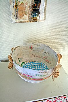 a white bowl sitting on top of a table next to a framed picture above it