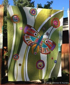 an image of a butterfly quilt hanging on a clothes line with the words, by bonnie hunter