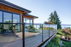 a deck with glass railing overlooking the ocean