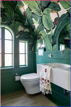 a bathroom with green painted walls and white fixtures