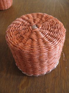 two wicker baskets sitting on top of a wooden table next to eachother