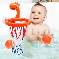 a baby in the bathtub playing with an orange basketball