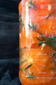 a jar filled with oranges sitting on top of a table