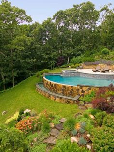 an above ground swimming pool surrounded by lush green trees and shrubs, with stone steps leading up to it