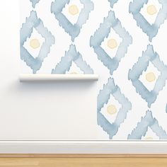 a white wall with a blue and yellow pattern on it next to a wooden floor