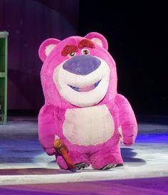 a large pink teddy bear standing on top of an ice rink