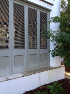 a cat sitting on the ledge of a window sill in front of a house