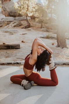 a woman is sitting on the ground with her hands behind her head and wearing red leggings