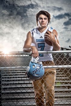 a female football player is holding a helmet and posing for a photo on the bleachers