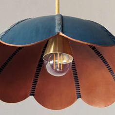 a light hanging from a ceiling fixture with a black and brown leather covering on it