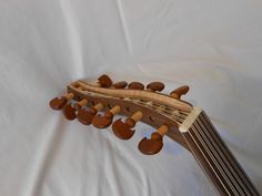 a ukulele made out of wood and strings on a white sheeted background