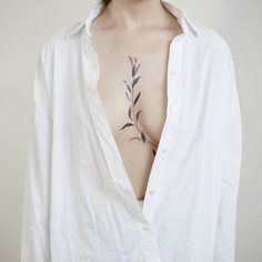 a white shirt with a black leaf tattoo on it's left chest and back