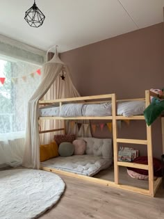 a bedroom with two bunk beds and a white rug on the floor in front of a window