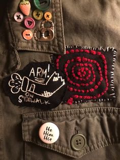 a close up of a person's jacket with buttons on the back and an embroidered badge