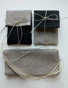 three pieces of cloth tied together with twine on top of each other, one black and one gray