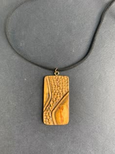 a wooden pendant is sitting on a gray surface